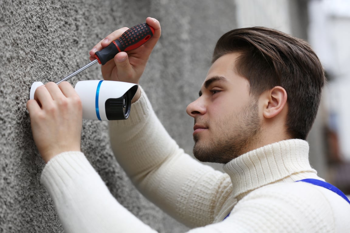 Technician Installing CCTV on the Wall 